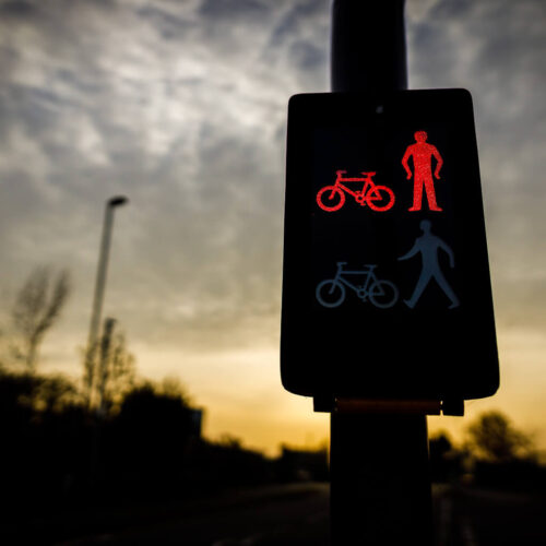 A close-up photo of a digital road sign indicating it is not safe to cross the road for pedestrians and bicyclists